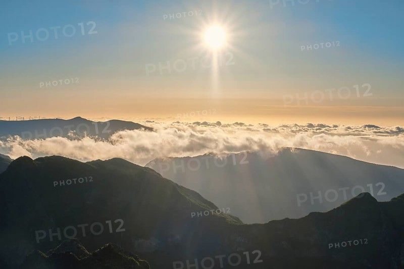 Aerial drone view of mountains over clouds near Pico Ruivo on sunset. Madeira island, Portugal, Europe