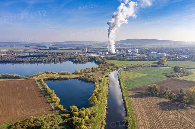 Drone shot of river Leine with Nordzucker sugar factory in Nordstemmen, smoking chimneys on a cold and sunny day, Germany, Europe