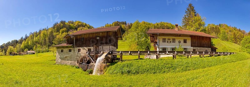 A traditional watermill in a rural setting with lush meadows and forests, Nussdorf Mühle