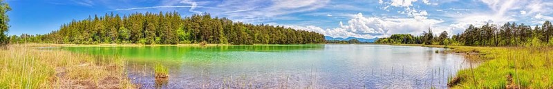 A panorama of a clear lake with vibrant colours and a surrounding forest, Osterseen