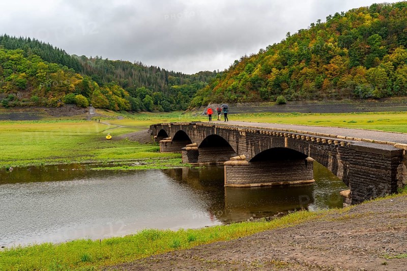 The Edersee, near Waldeck, the third largest reservoir in Germany, currently has only just under 13% of its normal level, the lake was last full in May 2022, dried out due to lack of rain, Asel bridge, exposed by the low water, otherwise flooded, the lake shore and the lake bottom is overgrown with fresh grass, Hesse, Germany, Europe
