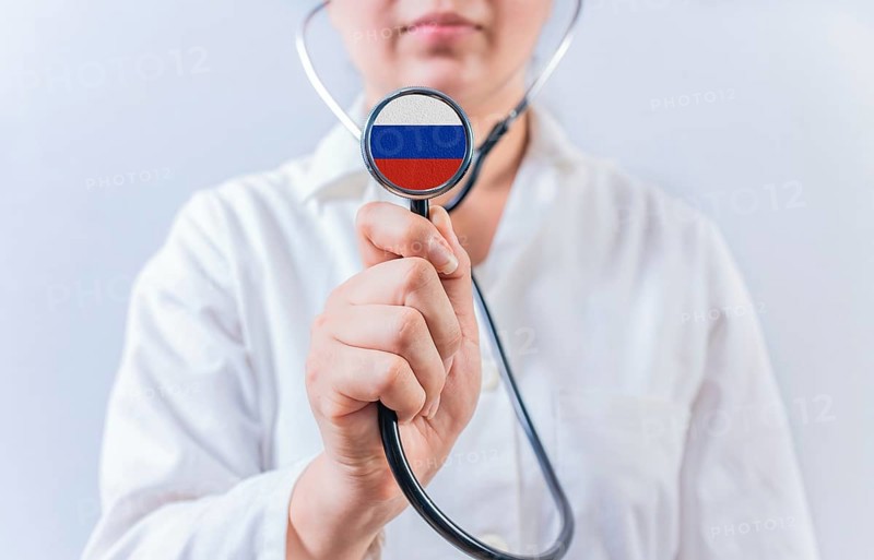 Female doctor holding stethoscope with with Russia flag. Russia health and care concept