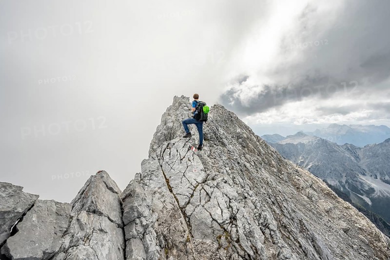 Mountaineer on a narrow rocky ridge, Watzmann crossing to Watzmann Mittelspitze, view of mountain panorama, Berchtesgaden National Park, Berchtesgaden Alps, Bavaria, Germany, Europe