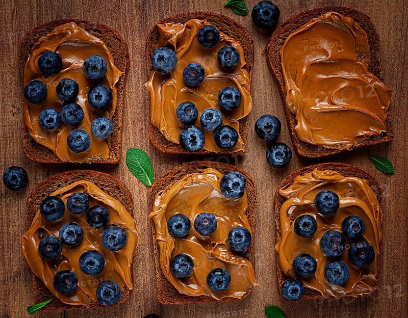 Rye bread with peanut paste and fresh blueberries, top view, no people
