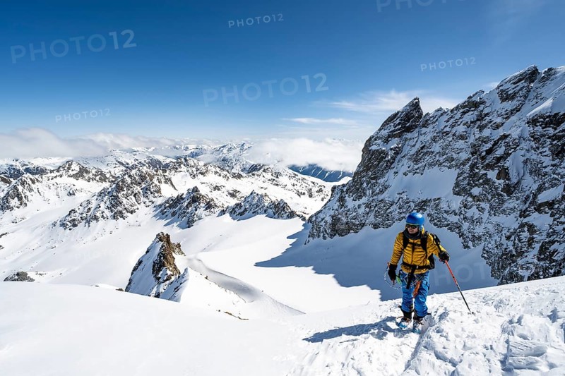 Mountaineer with ice axe and crampons, ascent through steep snowfield to Piz Kesch or Piz d'Es-cha in winter, view of mountain panorama with Vadret da Porchabella glacier, Albula Alps, Rhaetian Alps, Grisons, Eastern Switzerland, Switzerland, Europe