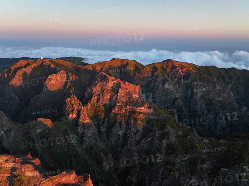 Aerial drone view of Pico do Arieiro and mountains over clouds on sunset. Above Pico Ruivo, Madeira island, Portugal, Europe