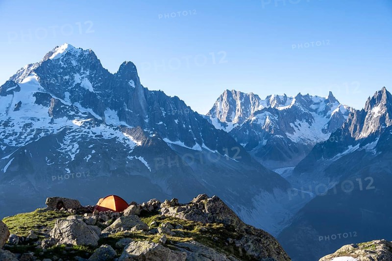 Red tent in front of a mountain panorama, mountain landscape in the morning light, mountain peaks Aiguille Verte and Grandes Jorasses, Mont Blanc massif, Aiguilles Rouges, Chamonix-Mont-Blanc, Haute-Savoie, France, Europe