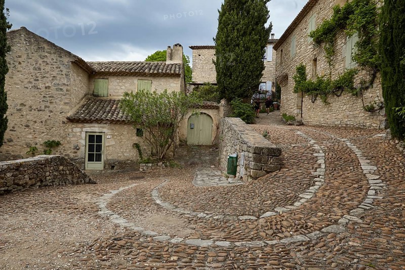 Winding path along old houses up a slope through La Roque-sur-Cèze, Département Gard, Occitania region, France, Europe