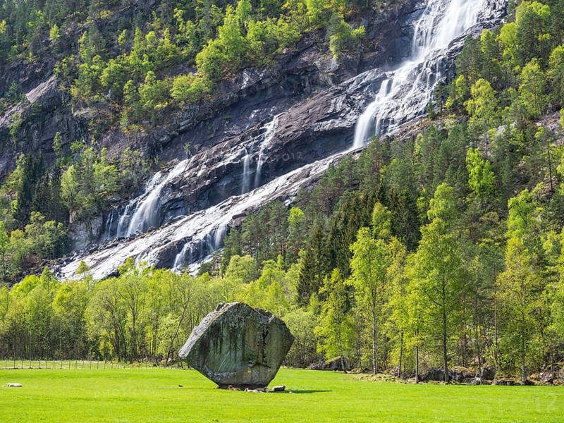 Waterfall Vidfossen, single large rock Oddmundsteinen, south of town Odda at fjord Sørfjord, branch of Hardangerfjord, Hordaland, Norway, Europe