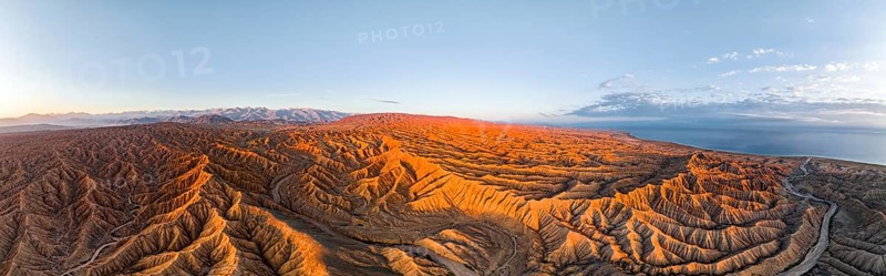 Panorama, landscape of eroded hills, badlands at sunrise, Issyk Kul Lake in the background, aerial view, Canyon of the Forgotten Rivers, Issyk Kul, Kyrgyzstan, Asia