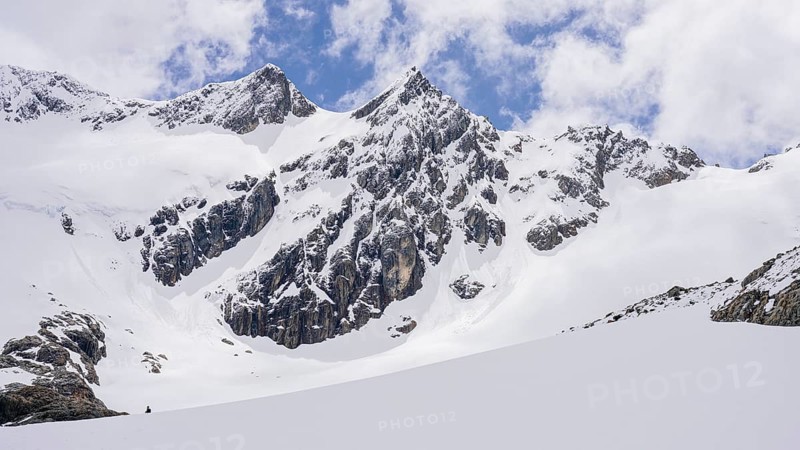 Glaciar Vinciguerra, Ushuaia, Tierra del Fuego Province, Argentinien, Verschneite Berggipfel ragen in einen teilweise bewölkten Himmel, Argentinien