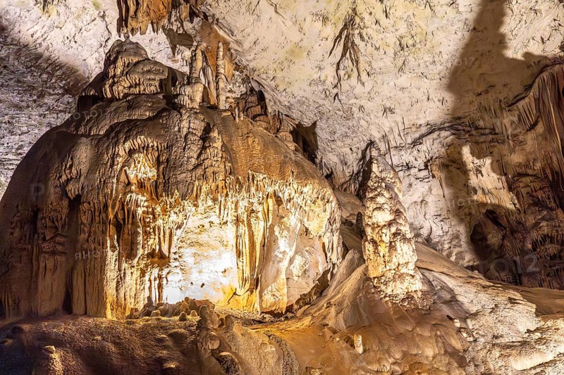 Large stalactites and stalagmites creating geological formations inside postojna cave, a famous tourist attraction in slovenia