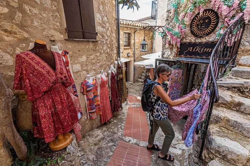 Women's clothing, woman, 62 y., in front of Boutique Alkimia in the mountain village Èze Village on the Côte d'Azur, Provence-Alpes-Côte d'Azur, France, Europe