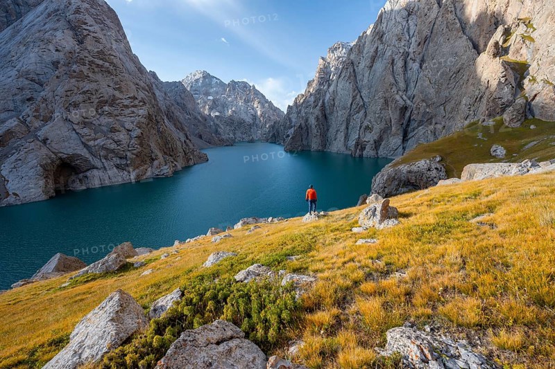 Tourist at the blue mountain lake between rocky steep mountain peaks, Kol Suu Lake, Sary Beles Mountains, Naryn Province, Kyrgyzstan, Asia