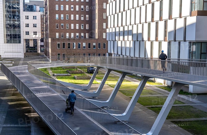 The Parkbruk, cycle and pedestrian bridge in the city centre of Antwerp, crosses a multi-lane city centre road with tram lines and thus connects two lively city districts Kop Spoor Noord and Eilandje, 140 metres of curved ramp on the western side for driving up and down, walking, Belgium, Europe
