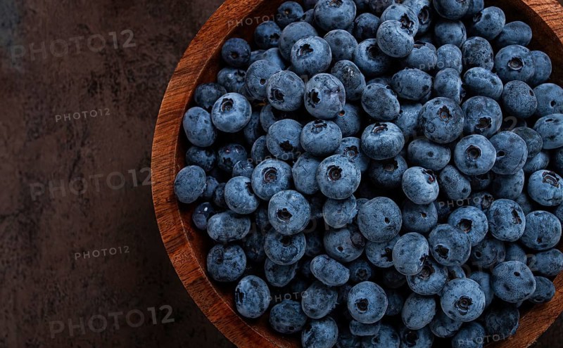 Fresh blueberries, in a wooden bowl, on the table, top view, close-up, no people