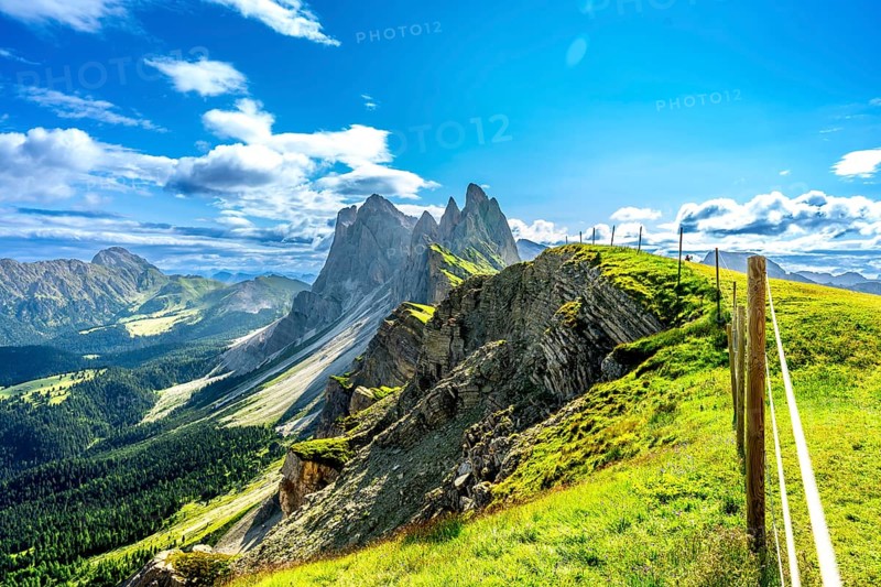 Majestic peaks of seceda rise above lush green valleys and meadows in the italian dolomites, a breathtaking summer vista