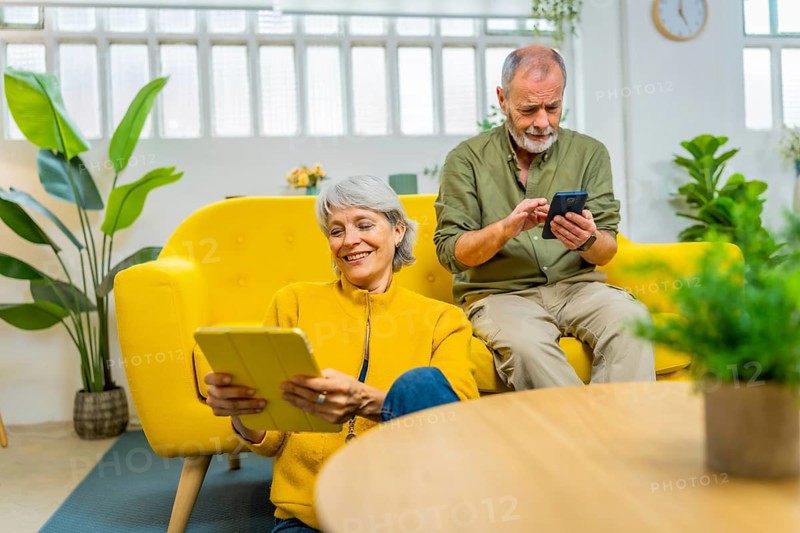 Senior couple using diverse devices and technology together at home