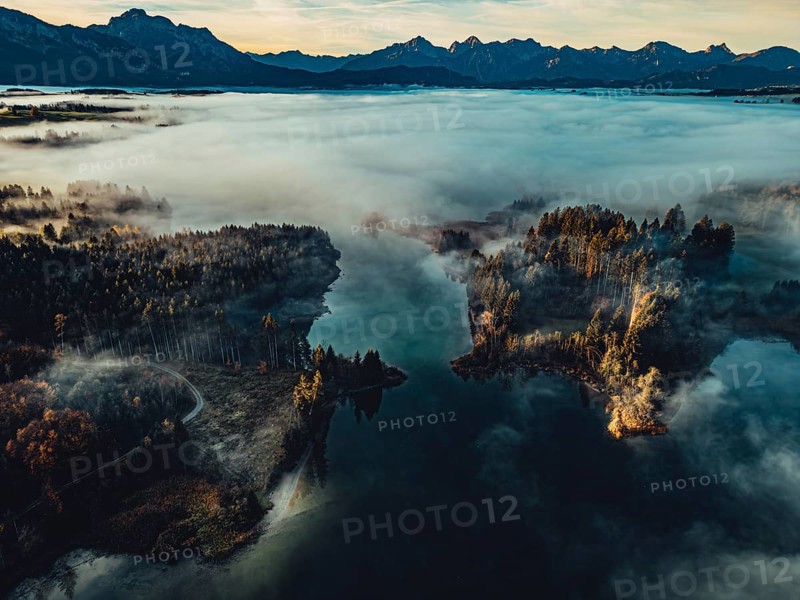 Autumn sunrise in the foothills of the Alps with fog at Illasbergsee and Forggensee near Halblech in Allgäu, Bavaria, Germany, Europe