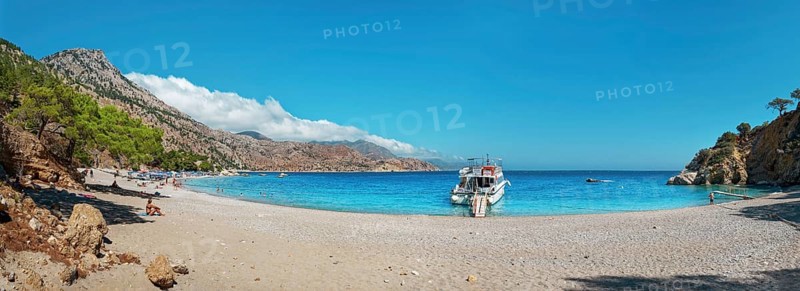 Coastal scene with a boat on Apella beach and blue sky, Apella beach, Karpathos, Greece, Europe