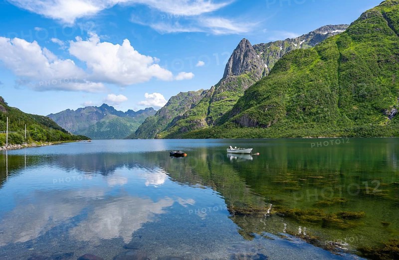 Small boats at the fjord Austnesfjorden, idyllic Norwegian fjord landscape, mountains reflected in the water, Sildpollen, Nordland, Norway, Europe