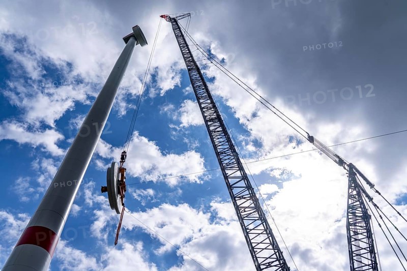 Erection of a wind turbine, wind energy plant, assembly of the ring generator, with a crawler lattice crane, wind farm near Hagen, North Rhine-Westphalia, Germany, Europe