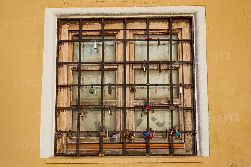 A shuttered window with bars in a yellow wall, harbour area, Rhodes Town, Rhodes, Dodecanese, Greek Islands, Greece, Europe