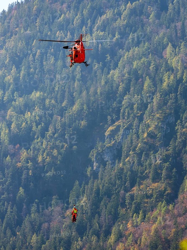 2 mountain rescuers of the Bavarian Mountain Rescue Service are winched by the on-board mechanic of the rescue helicopter Christoph 14 with the cable winch, Bad Reichenhall, Berchtesgadener Land, Upper Bavaria, Bavaria, Germany, Europe