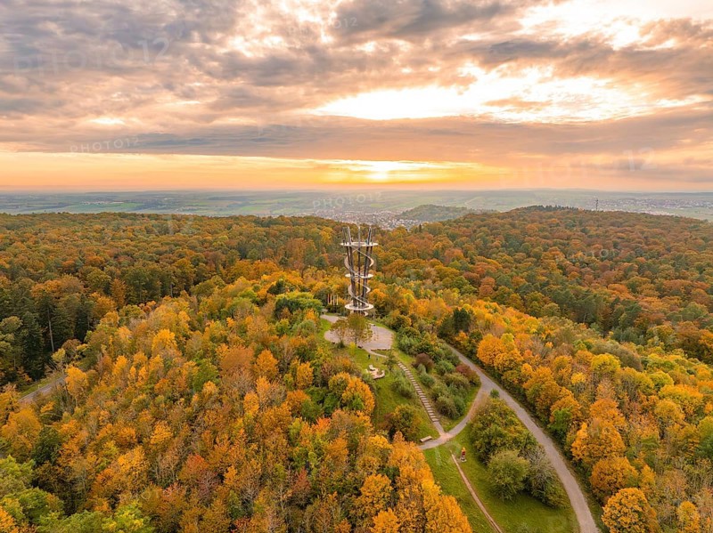 Majestic tower amidst a vibrant autumn forest under a dramatic sunset sky, Schönbuchturm, Herrenberg, Germany, Europe