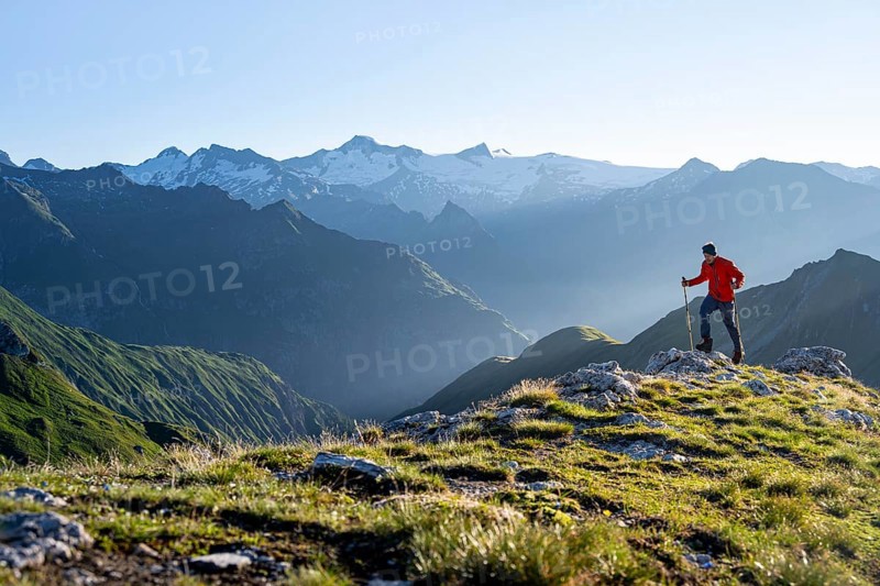 Hiker enjoying the mountain panorama in the morning, Venediger group, behind Dreiherrenkopf, Simonysitze and Großer Geiger, Hohen Tauern, Austria, Europe