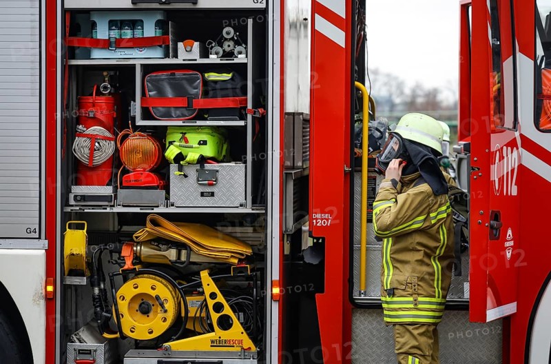 Duisburg, North Rhine-Westphalia, Germany, firefighting exercise, people are rescued from a burning flat. Firefighter returns to the fire engine after the operation. Press event: Federal Chancellor Olaf Scholz visits Fire Engine 530 of the Duisburg Volunteer Fire Brigade at Fire and Rescue Station 5 in Homberg. Together with a training unit of the professional fire brigade, the fire brigade school is also housed there, Europe