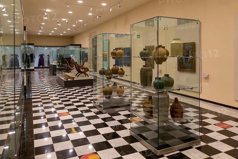 Interior of city museum, Campeche city, Campeche State, Mexico display cabinets of pottery and furniture