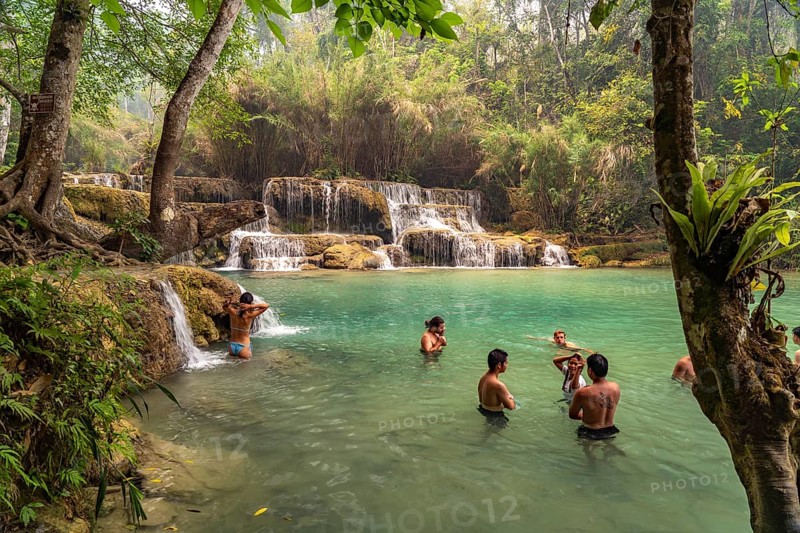 Tourists bathing in the Kuang Si waterfall near Luang Prabang, Laos, Asia