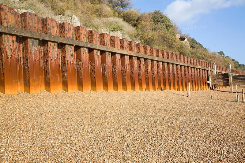Rusty steel piling sea wall defences and shingle beach near Bawdsey Quay, Suffolk, England, United Kingdom, Europe