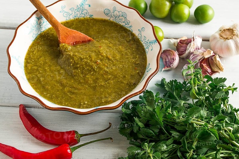 Tkemali sauce, traditional Georgian cuisine, green cherry plum, with ingredients for sauce, cilantro, mint, hot pepper, garlic, on a white wooden table, close-up, rustic, food background, no people, selective focus, sauce, green sauce, tkemali, georgian cuisine, homemade
