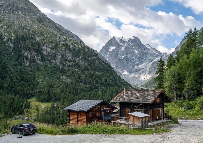Wooden houses in the mountain village of Arolla, behind mountain peak Mont Collon, Valais, Western Alps, Switzerland, Europe