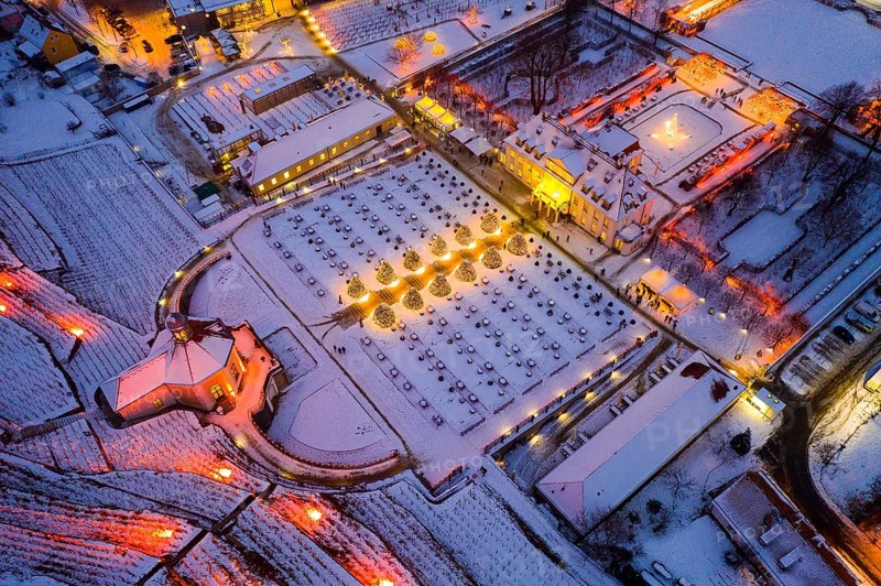 Aerial view of Wackerbarth Castle with castle park, belvedere and vineyards with snow and Christmas lights, Radebeul, Saxony, Germany, Europe