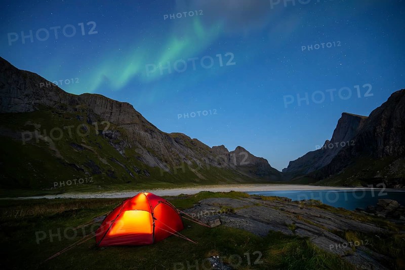 Northern lights over tent on Horseid beach, sandy beach with mountains, Lofoten, Norway, Europe