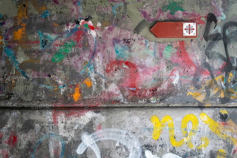 Graffiti-covered concrete wall with Olav's Cross signposting for pilgrims on the Olav Trail or Olavsleden, Oslo, Norway, Europe