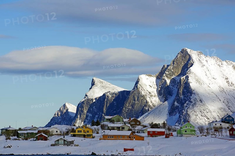 Colourful houses on snowy hills and mountains under a blue sky with few clouds, peaceful winter landscape, Ramberg, Flakstad, Lofoten, Nordland, Norway, Europe