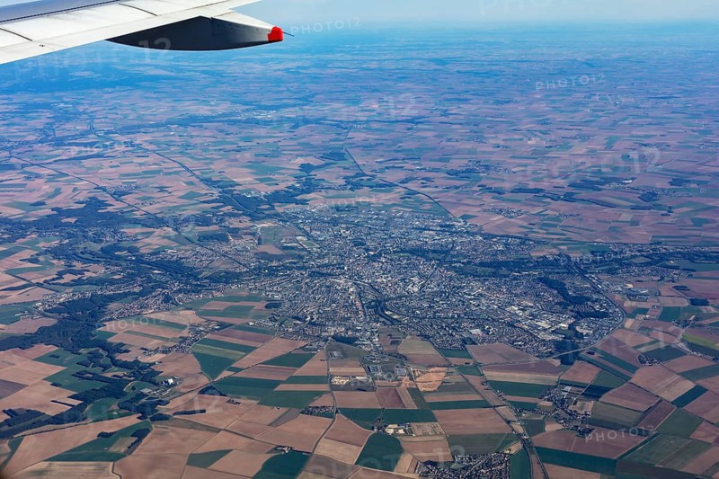 View from an aeroplane over fields and a cityscape, flight, aerial view