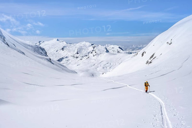 Lone ski tourer in a mountain landscape with snow, summit Wildhorn in the background, ascent to Wildstrubelhütte, Bernese Alps, Switzerland, Europe
