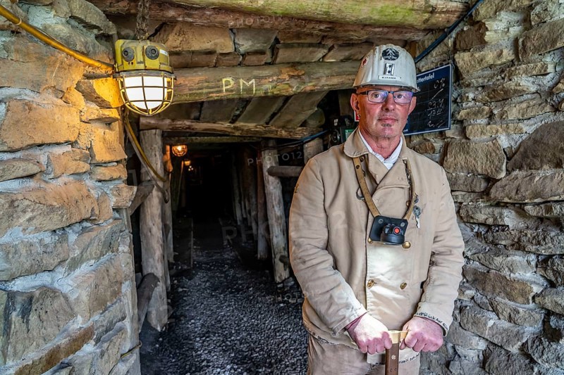 Visitor group at the entrance to the Nachtigallstollen, tour guide, GeoRoute Ruhr, Dünkelberg quarry, in the Muttental valley, here you can see the geology of the region, a thin coal seam is visible, underneath were thicker layers of coal that were mined, Witten, North Rhine-Westphalia, Germany, Europe