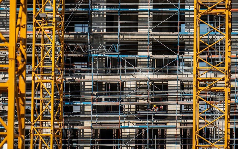 Construction site, at the Cologne Trade Fair Centre, new construction of a high-rise office building, construction cranes, facade of the shell, scaffolding, construction crane, North Rhine-Westphalia, Germany, Europe