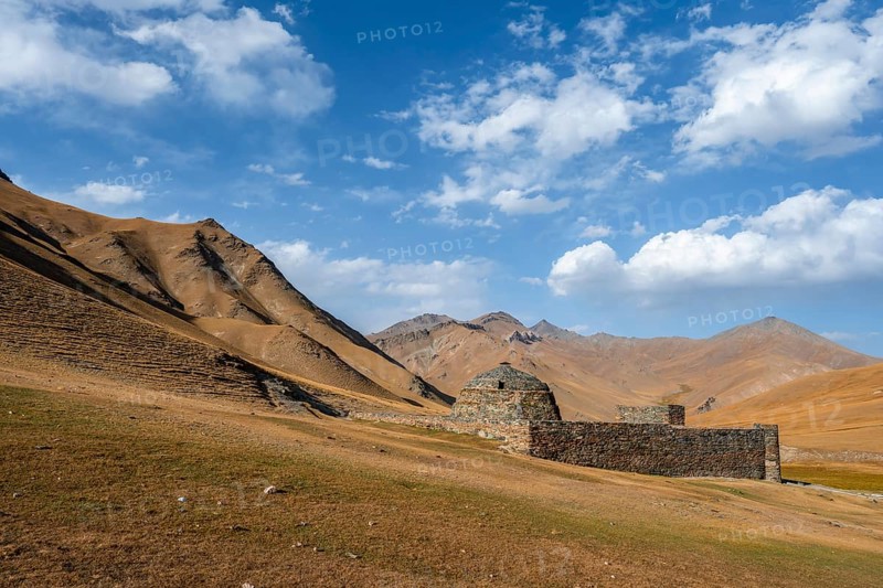 Historic caravanserai Tash Rabat from the 15th century, with yellow hills, Atbashy district in the Naryn region, Kyrgyzstan, Asia