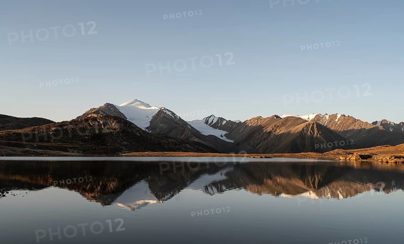 Glaciated mountain peaks reflected in a mountain lake at sunset, Arabel Lake at Arabel Pass, Issyk Kul Province, Kyrgyzstan, Asia
