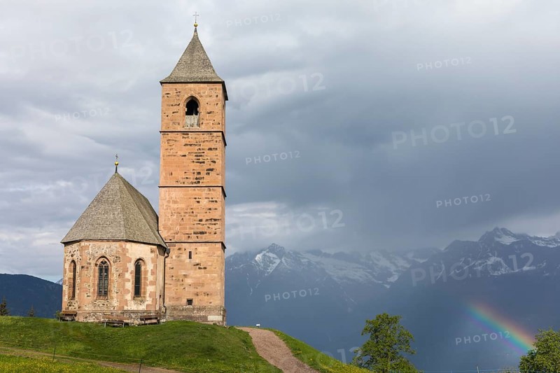 Church St. Kathrein, 39010 Hafling, Italy with a rainbow in the background. The church is from the 13 th century