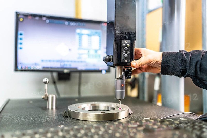 Close-up of the hand of a technician working with three-dimensional verification and measuring machine in a cnc innovative metal factory