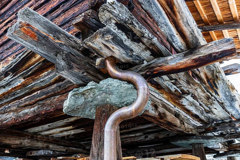 Old weathered hay barn with wooden support, stone slab and copper pipe, Chandolin, Val d'Anniviers, Valais Alps, Canton Valais, Switzerland, Europe