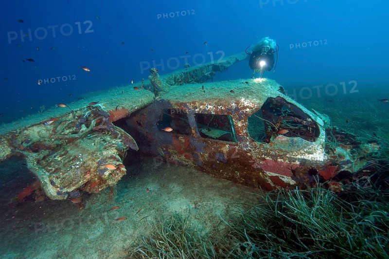 Diver looking at Cessna aircraft wreck underwater on the seabed while scuba diving, Porto Azzurro, Elba, Tuscany, Italy, Europe, Mediterranean Sea, Europe